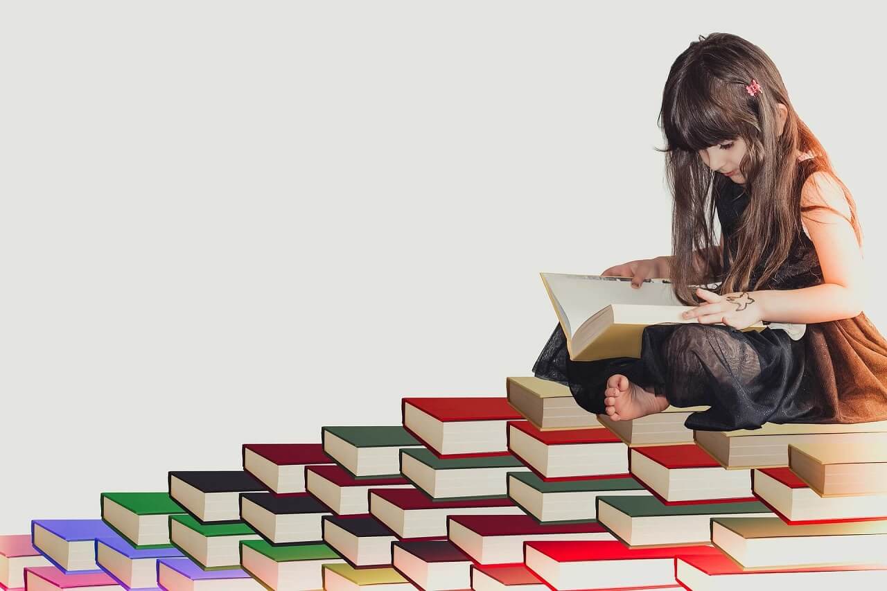 Girl reading on a stack of books